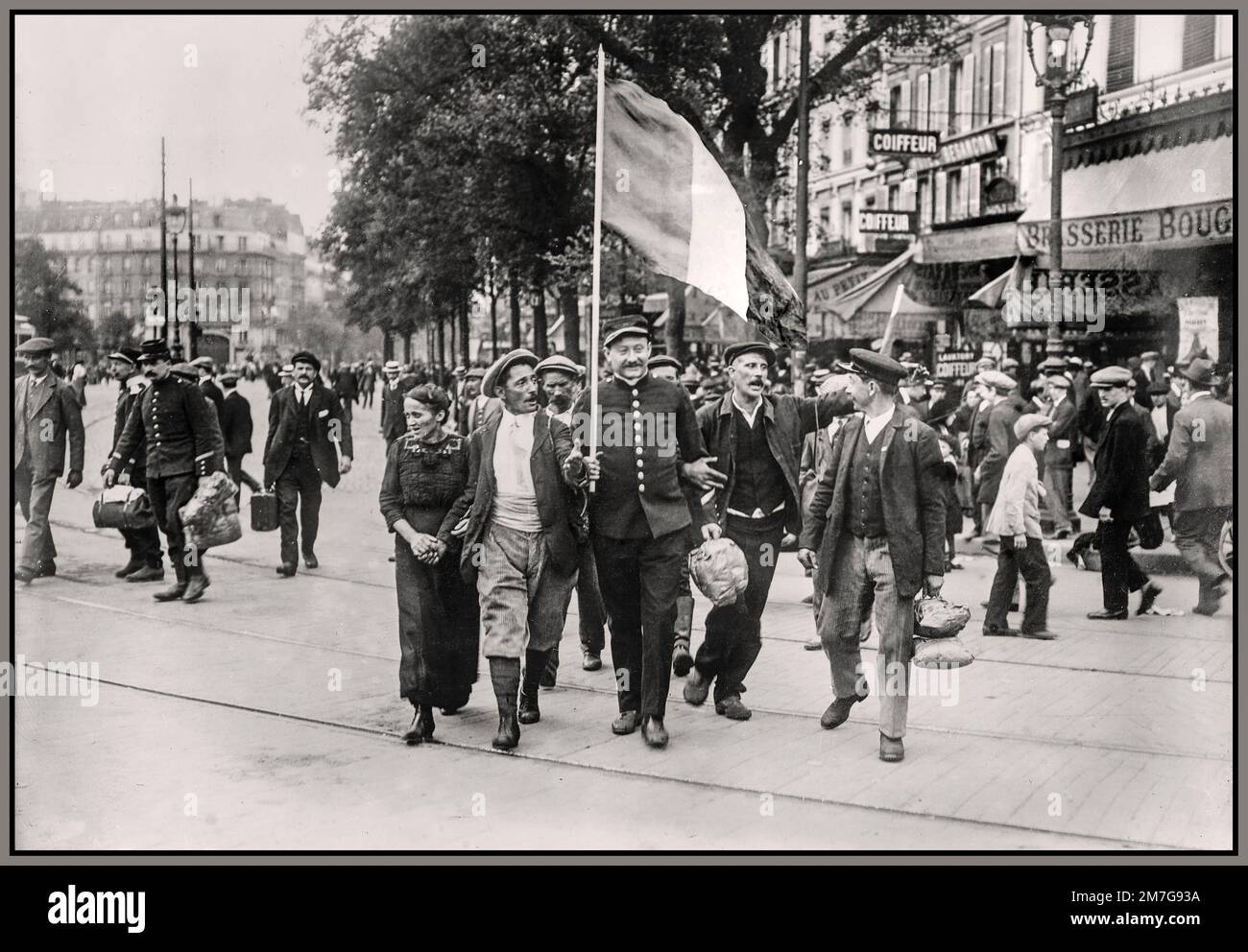 WW1 Paris Patriotic French Reservists going to war via the Rail station in Paris France. French reservist soldiers marching in front of the Brasserie Bougeneaux (9 Rue de Strasbourg), Paris, France, on their way to the Gare de l'Est, to the front by train during World War I. Date between ca. 1914 and ca. 1915 Stock Photo