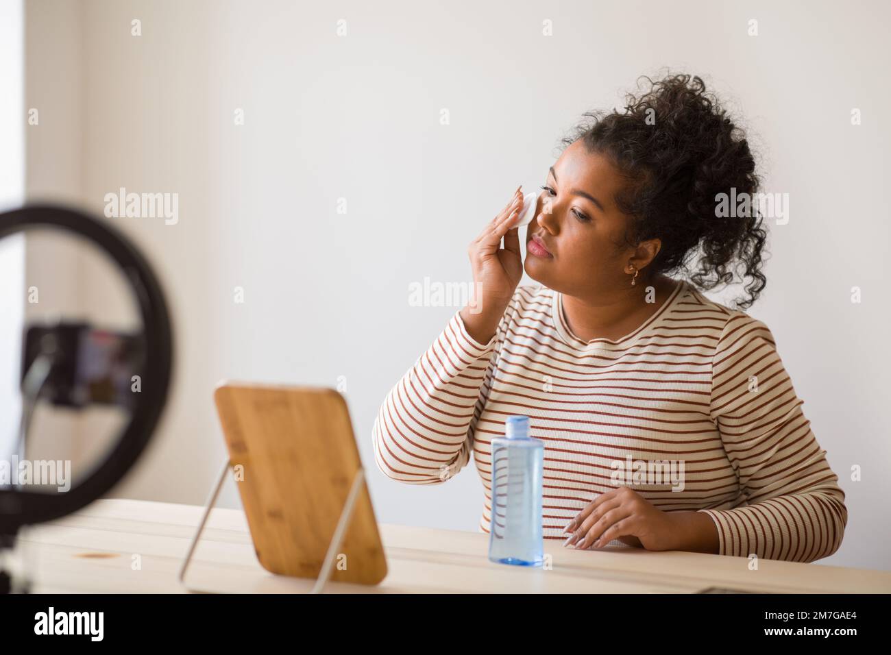 Young lady plus size using face toner and recording video Stock Photo