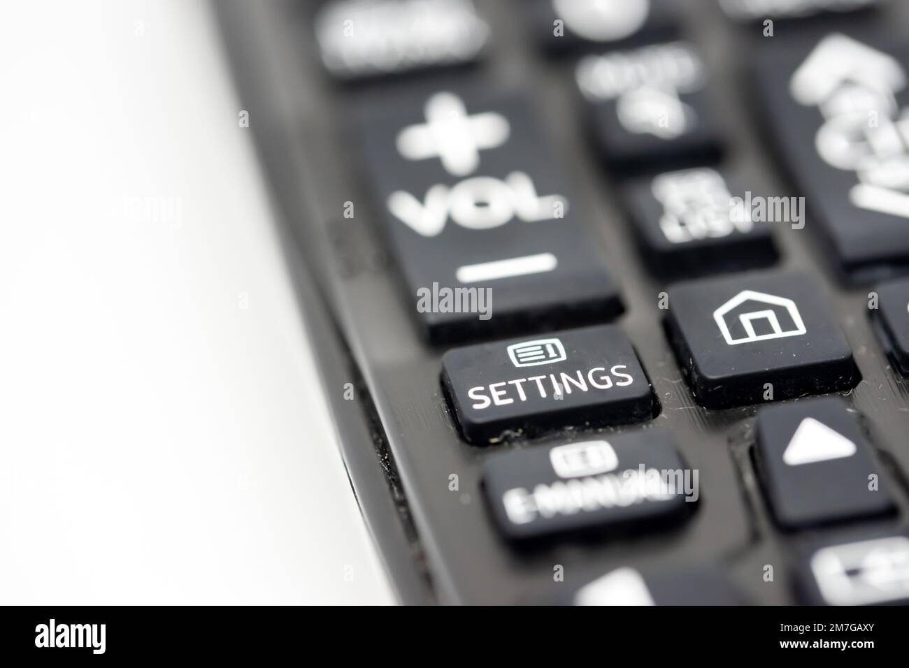 Close-up of a TV remote control with focus on the settings button Stock Photo