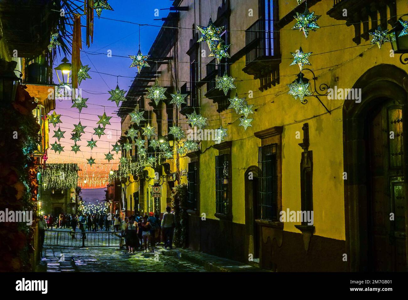 Colorful tin star decorations strung across historic buildings on Canal