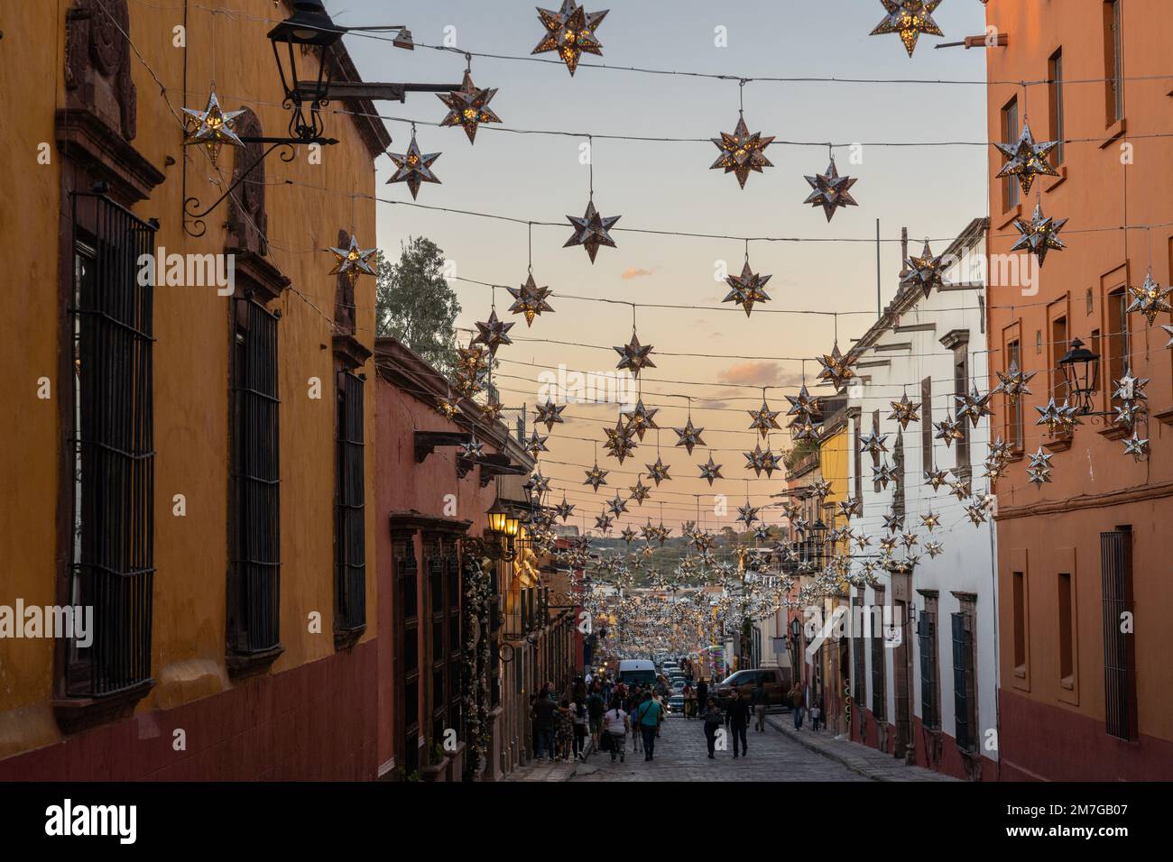Colorful tin star decorations strung across historic buildings on