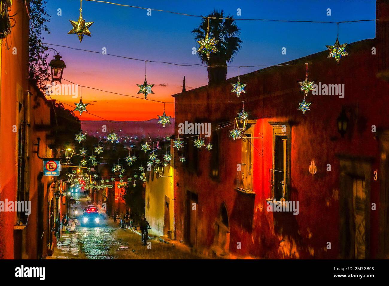 Colorful tin star decorations strung across historic buildings on