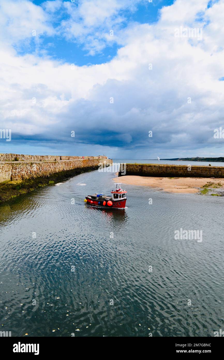 A small fishing boat enters the Harbour at St Andrews, Scotland. Stock Photo