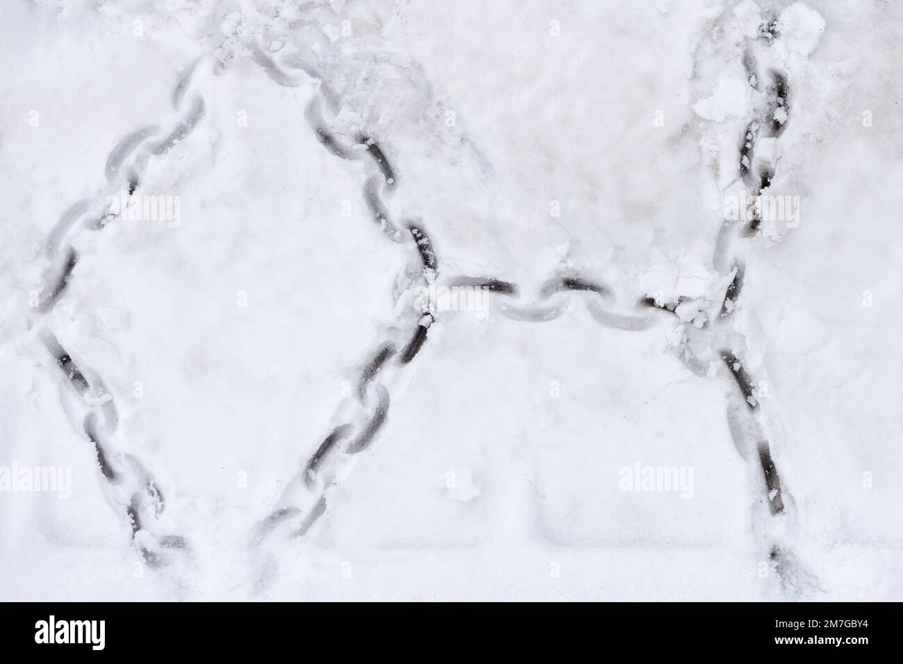 Tire texture on snow. Snow chain marks on an icy road. Track from the