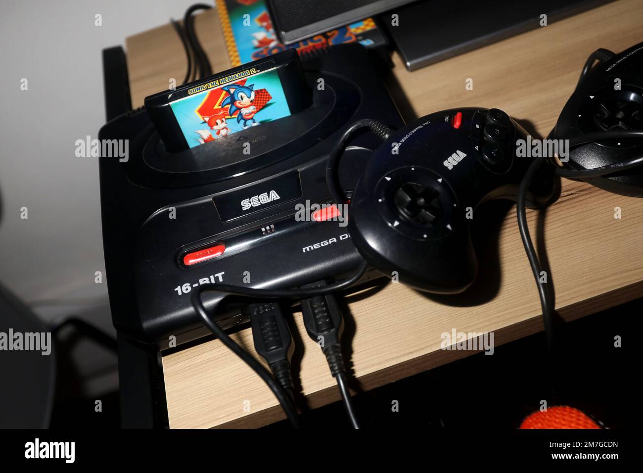 An old Sega Megadrive games console pictured connected up to a TV with Sonic the Hedgehog game plugged in to play. Havant, Hampshire, UK. Stock Photo