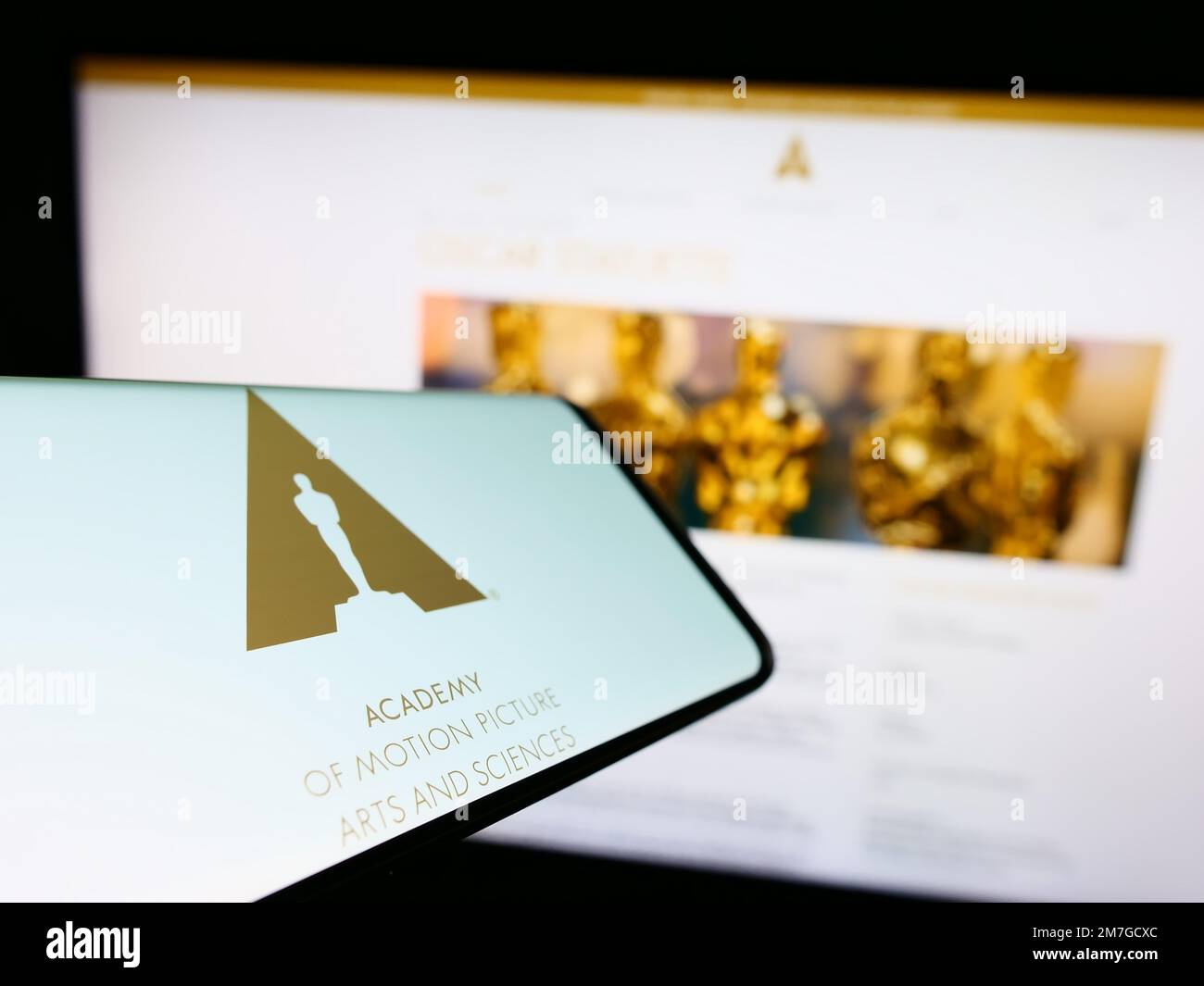 Mobile phone with logo of Academy of Motion Picture Arts and Sciences (AMPAS) on screen in front of website. Focus on center-left of phone display. Stock Photo