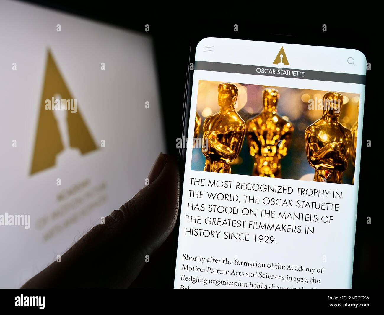 Person holding smartphone with website of Academy of Motion Picture Arts and Sciences (AMPAS) on screen. Focus on center of phone display. Stock Photo