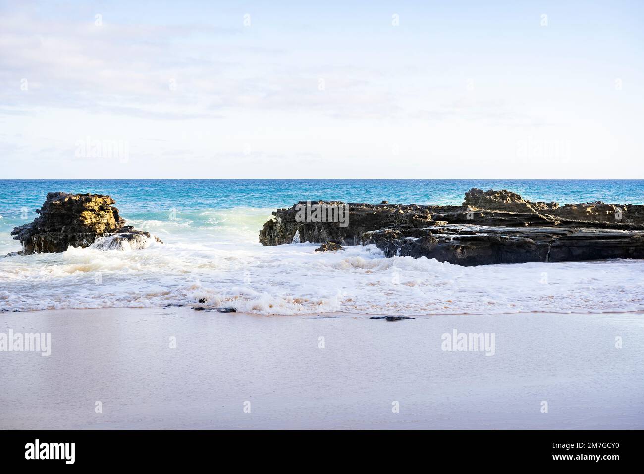 Sea waves hitting rocks at the beach Stock Photo - Alamy