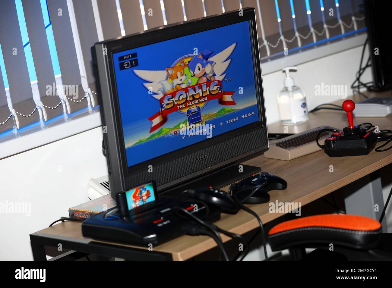 An old Sega Megadrive games console pictured connected up to a TV with Sonic the Hedgehog game plugged in to play. Havant, Hampshire, UK. Stock Photo