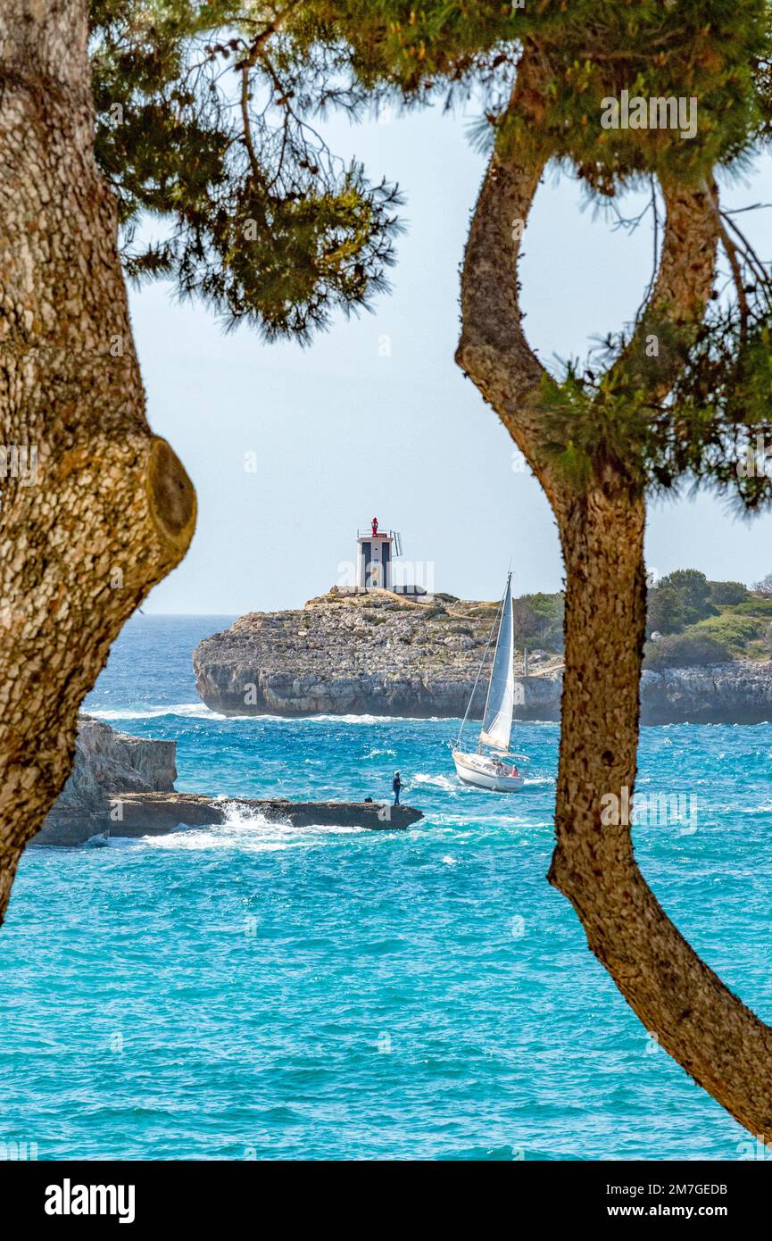 Angler and sailboat leaving the bay of Porto Cristo, Mallorca Stock Photo