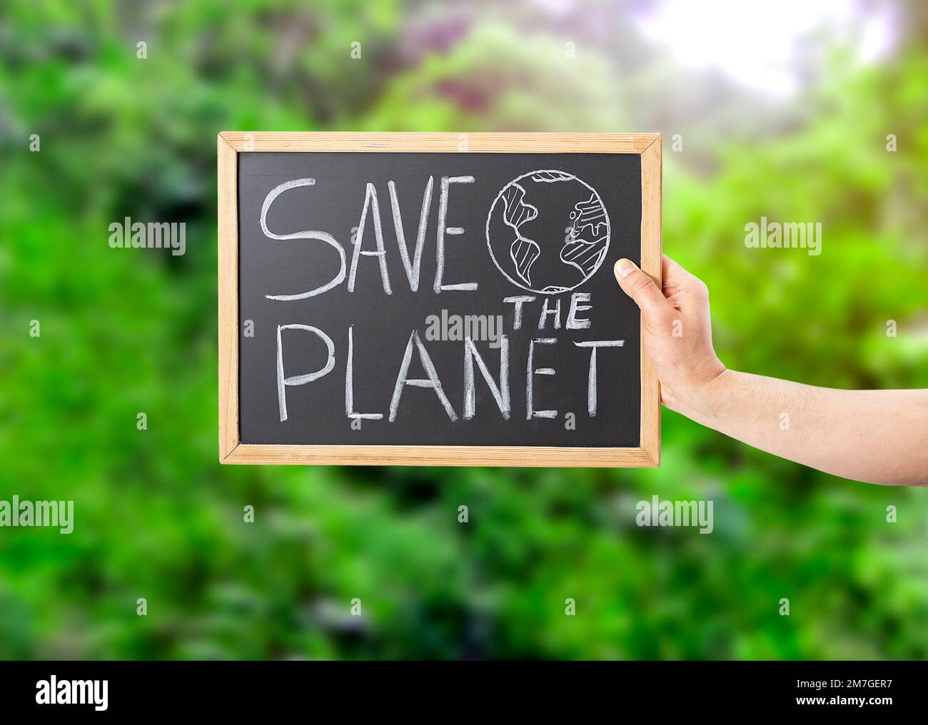 Closeup shot of a man's hand holding a blackboard sign that says SAVE