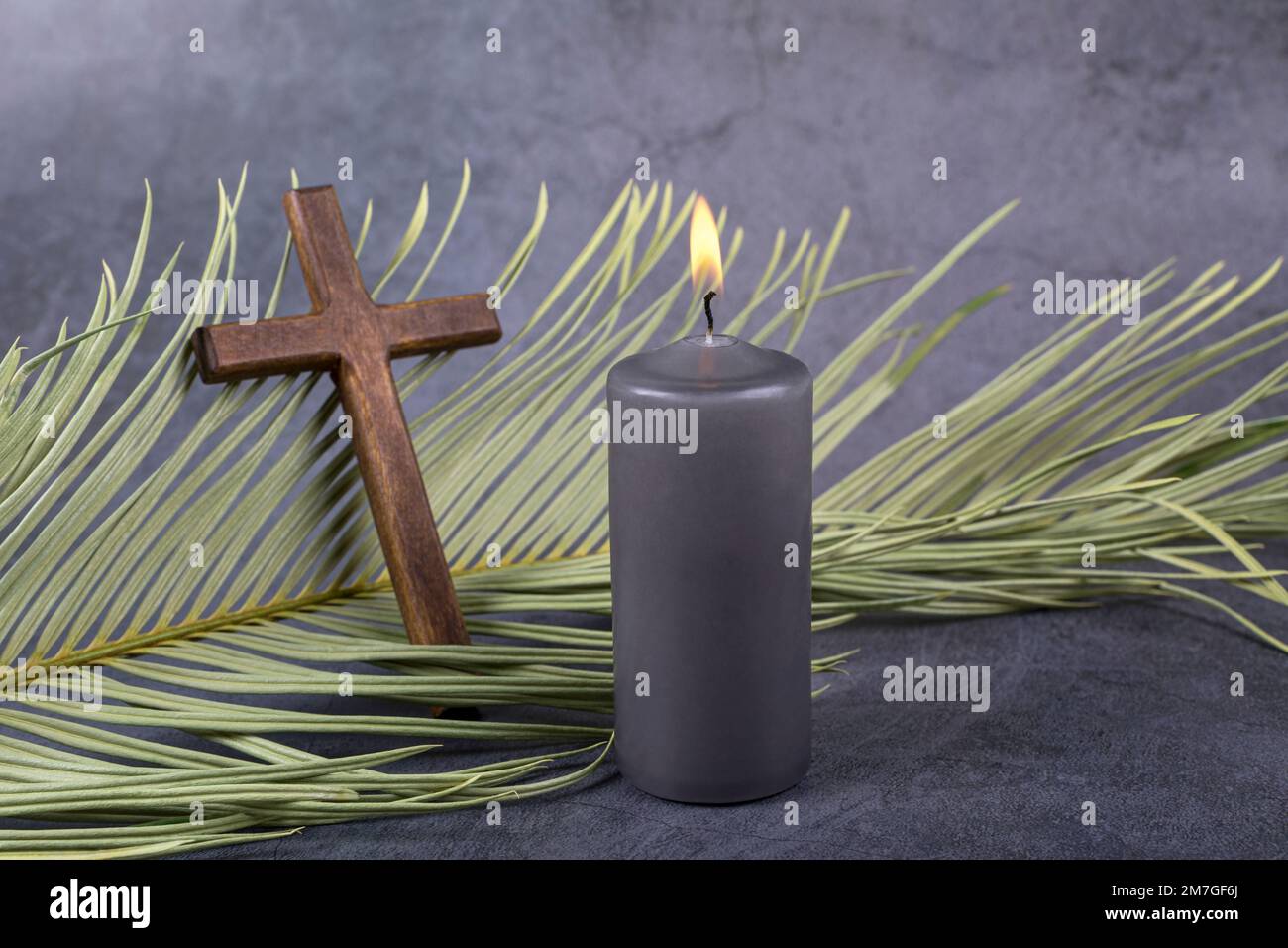 Catholic Cross with palm leaf and burning candle. Ash Wednesday, Lent