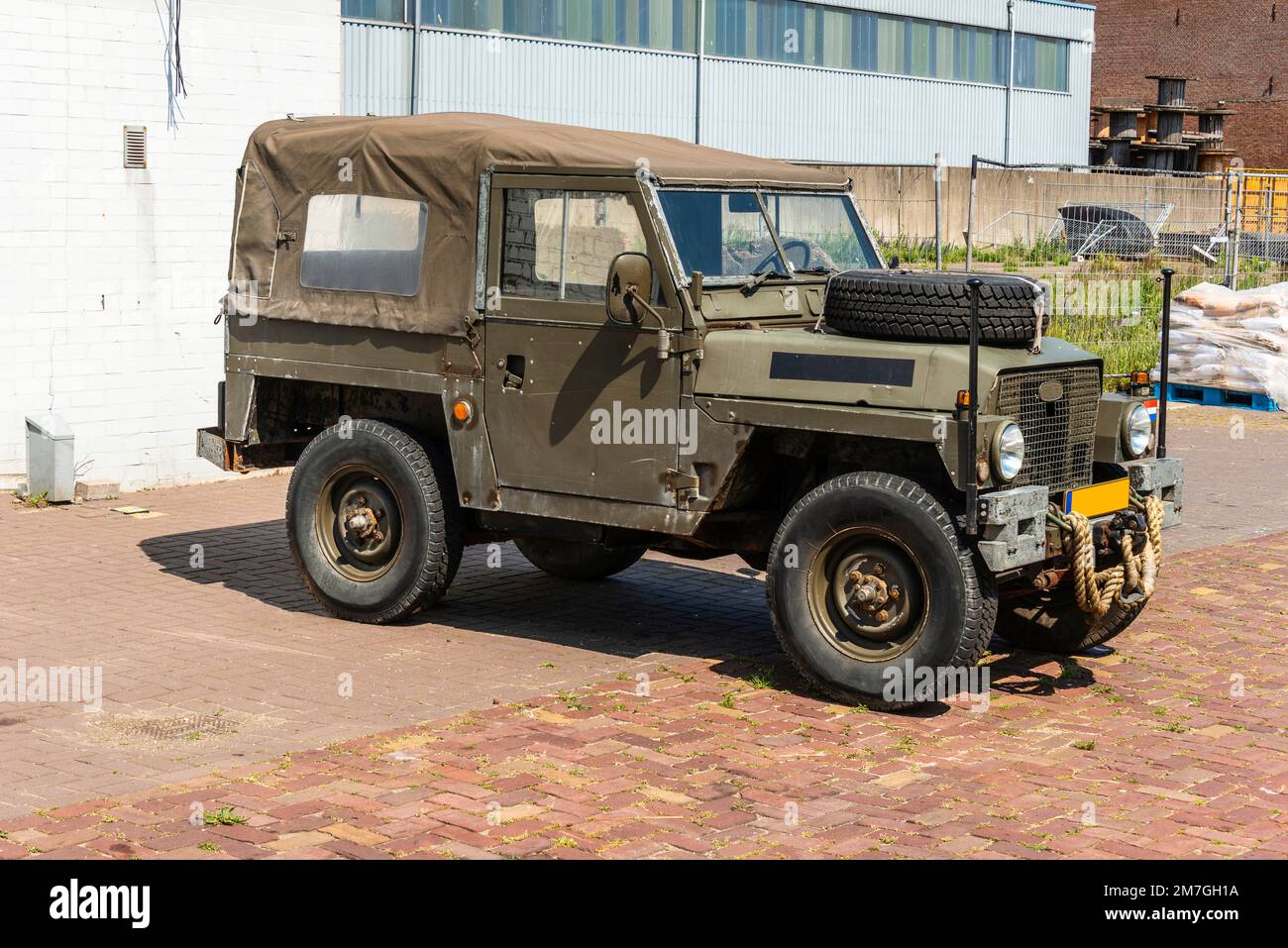 old green army land rover parked in an industrial area Stock Photo