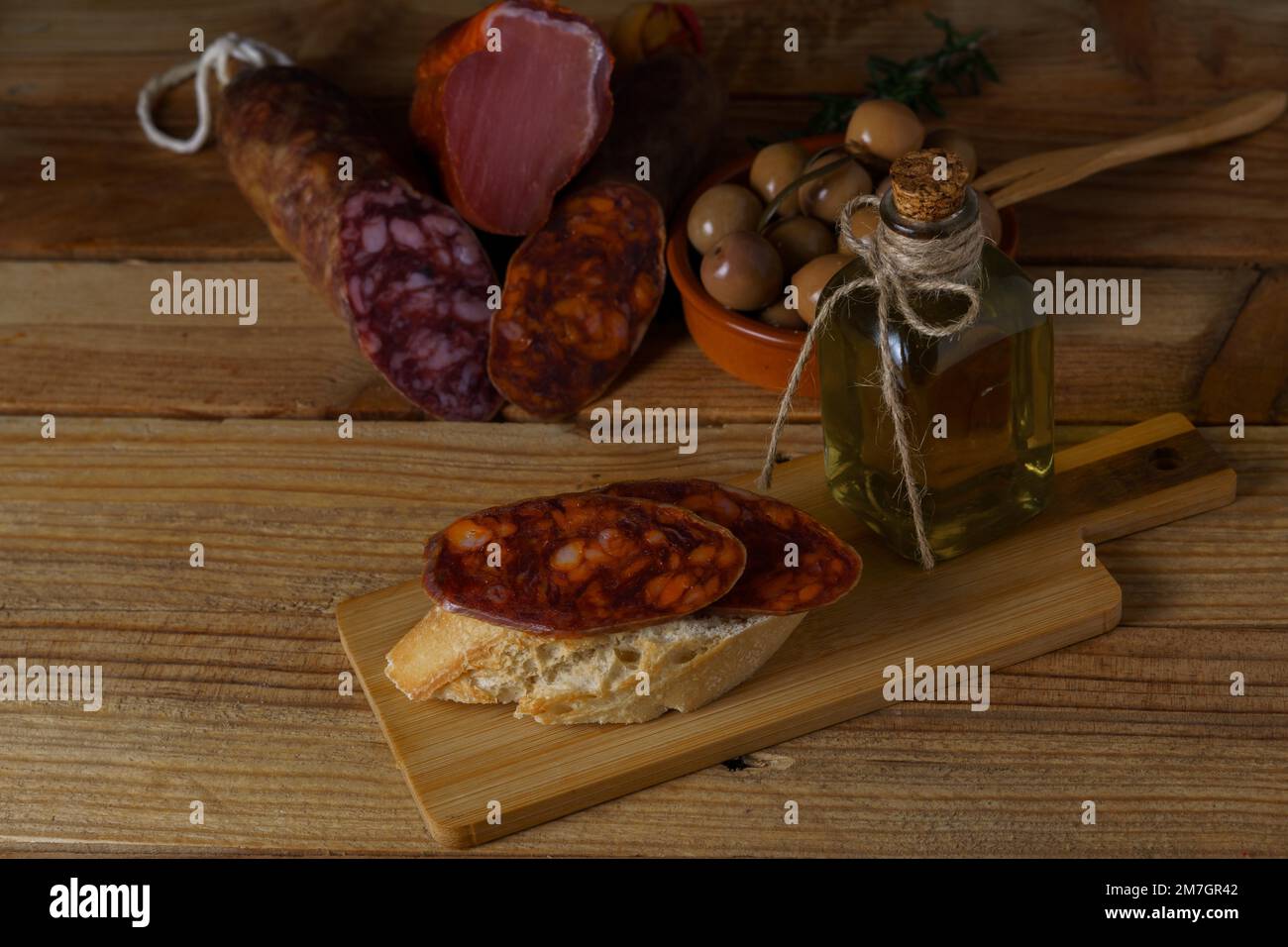 Tapa of iberian chorizo on rustic bread with olive oil on a wooden ...