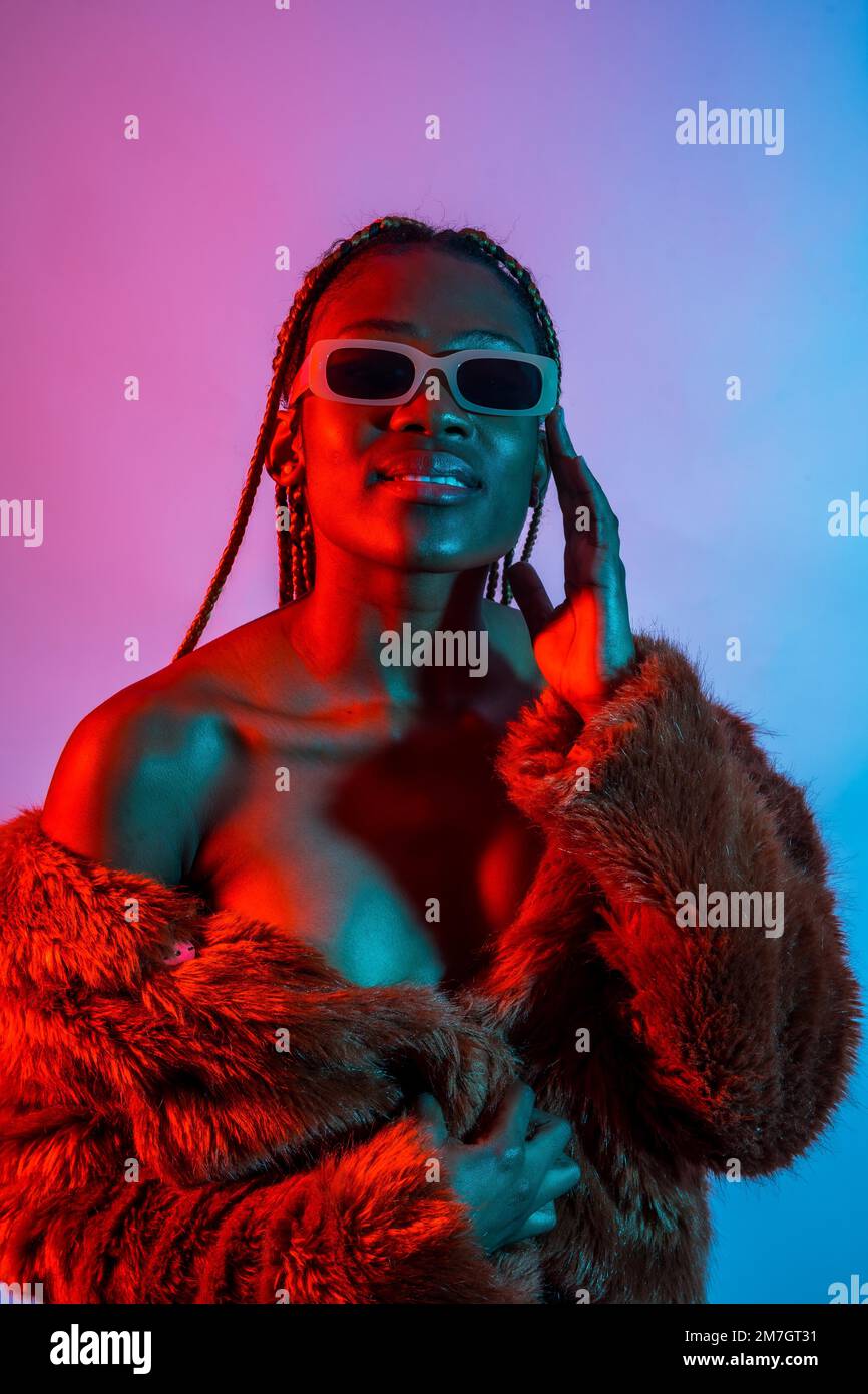 Attractive black ethnic woman with braids with red and blue led lights, trap dancer wearing sunglasses Stock Photo