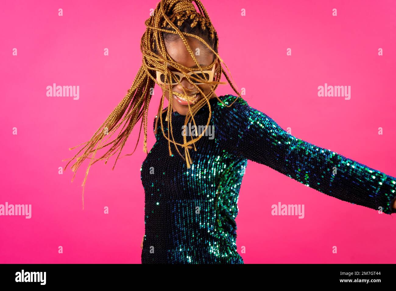 African young woman with party braids on a pink background, smiling ...