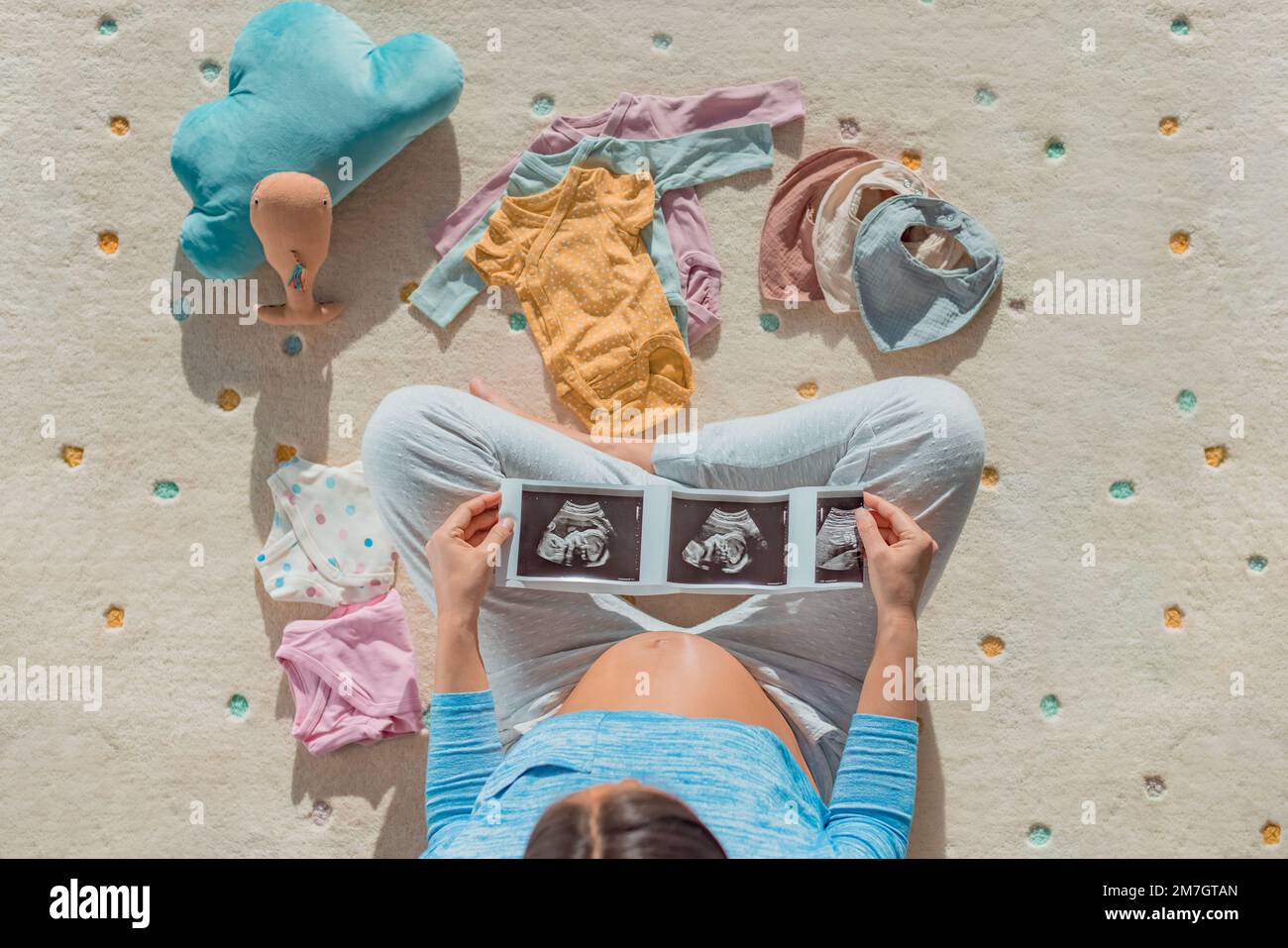 Pregnancy photo. Pregnant woman looking at first ultrasound photo of her baby with belly baby bump showing happily awaiting the birth of her child Stock Photo