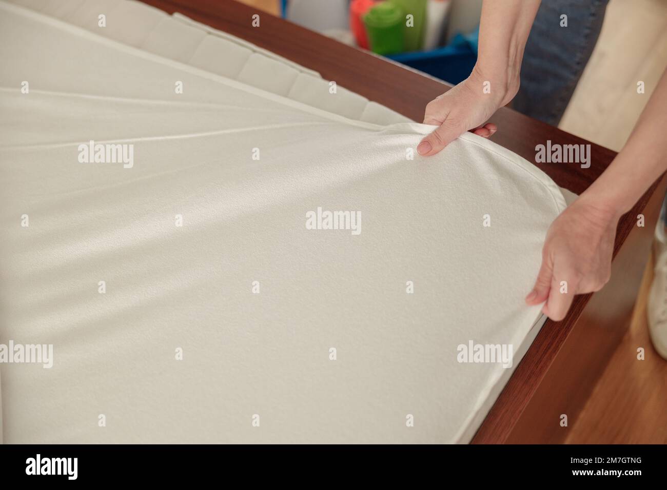 Close up of cleaning lady doing housekeeping and making bed in hotel