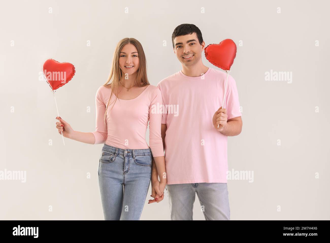 Young couple in love with balloons on light background. Valentine's Day ...