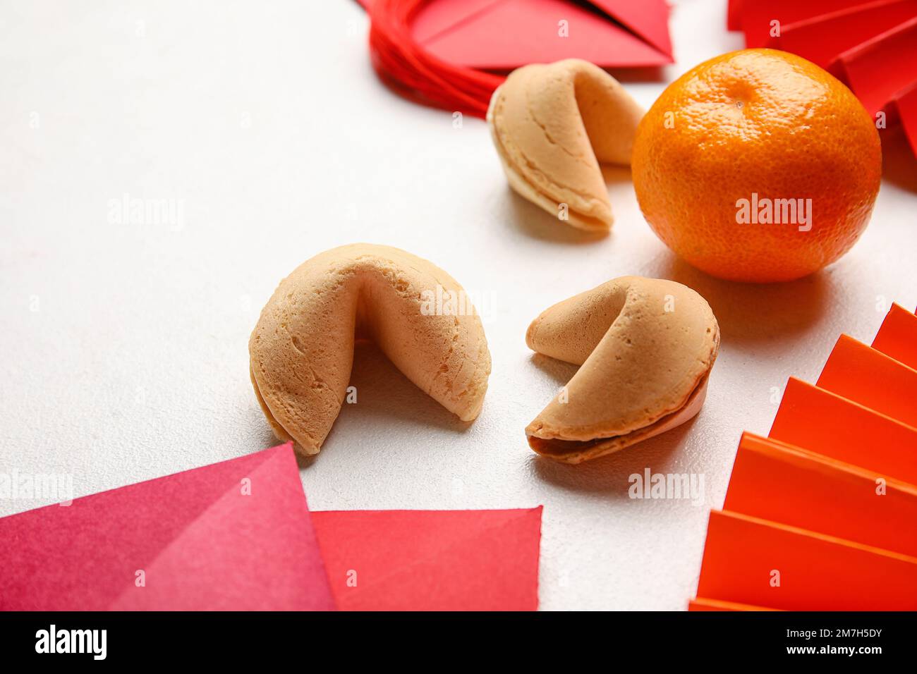 Fortune cookies with mandarin on white background, closeup. Chinese New