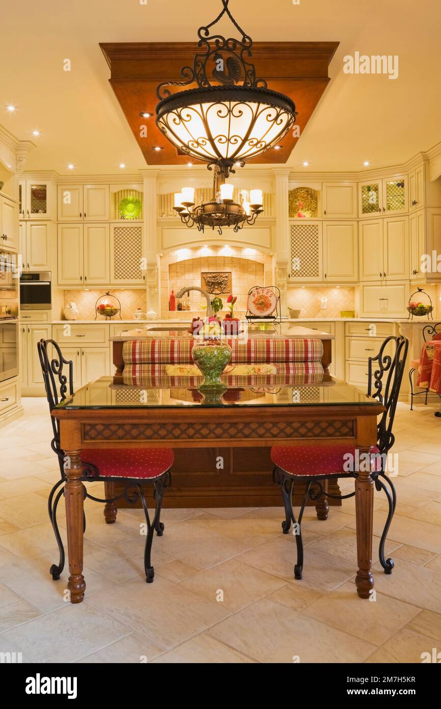 Illuminated chandeliers above breakfast table and red upholstered