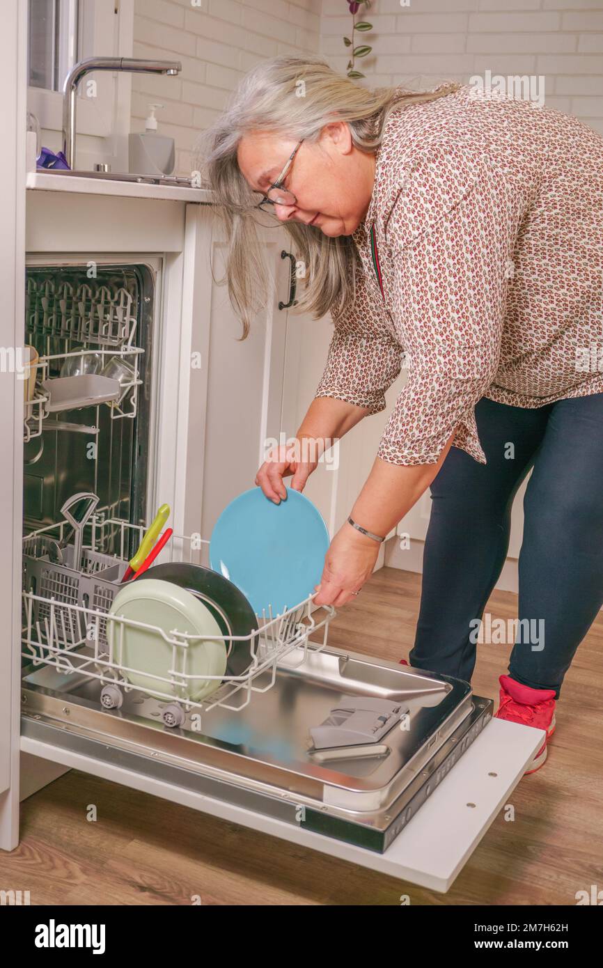 woman putting the dishes in the dishwasher Stock Photo Alamy