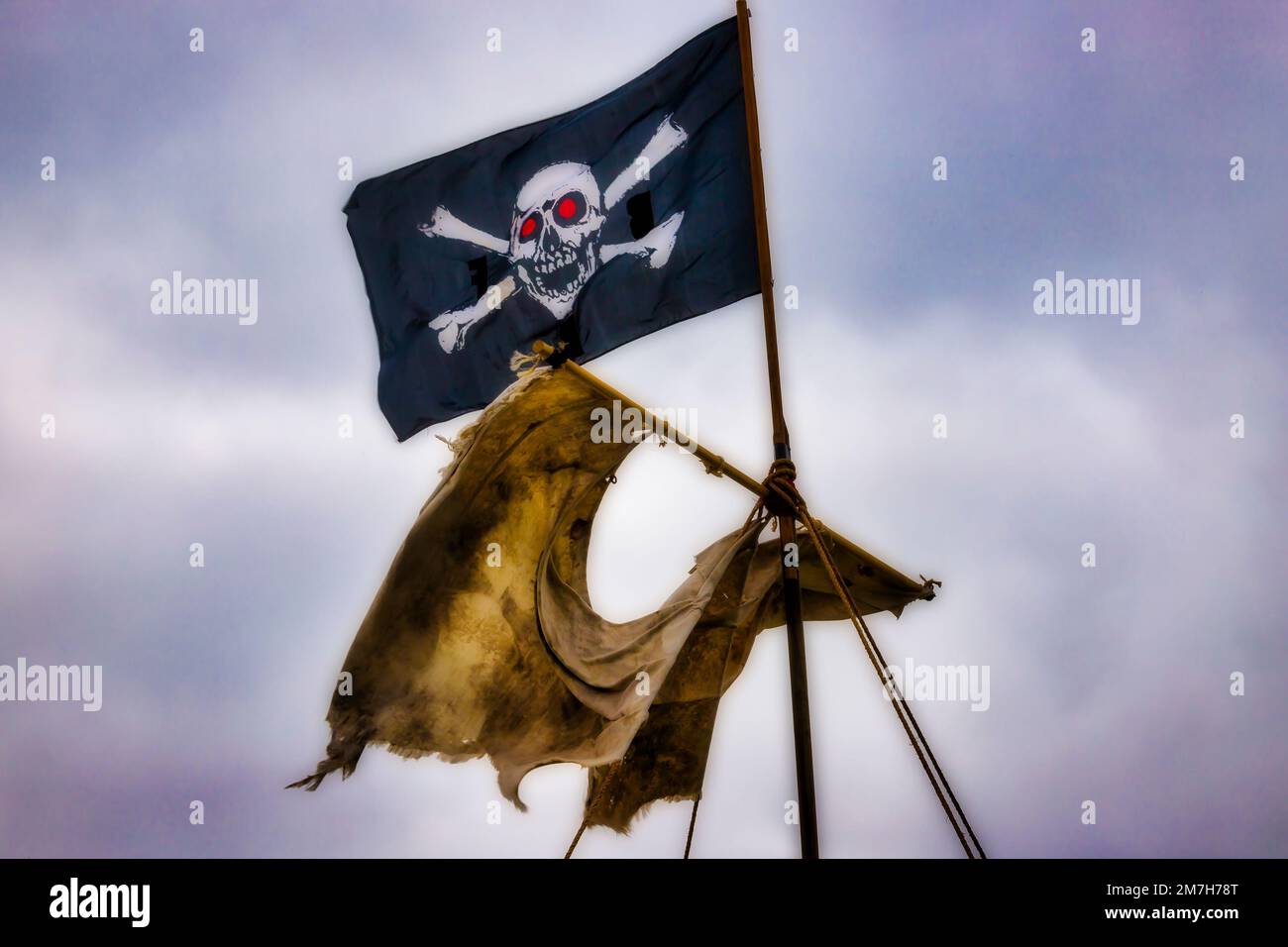 Tattered Sail And Pirate Flag Stock Photo