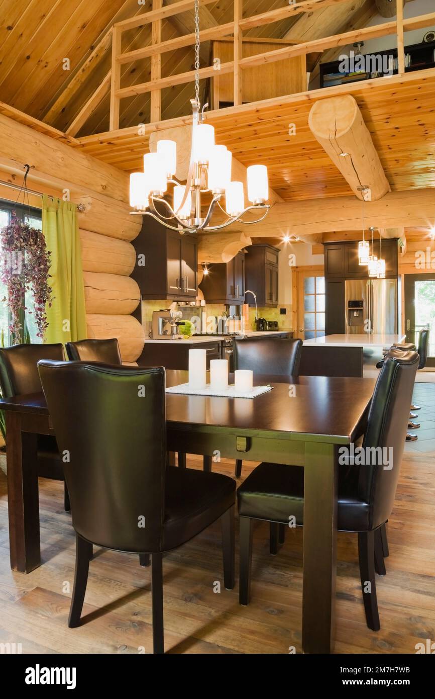 Brown stained pine wood dining table and brown leather high back chairs in dining room plus ...