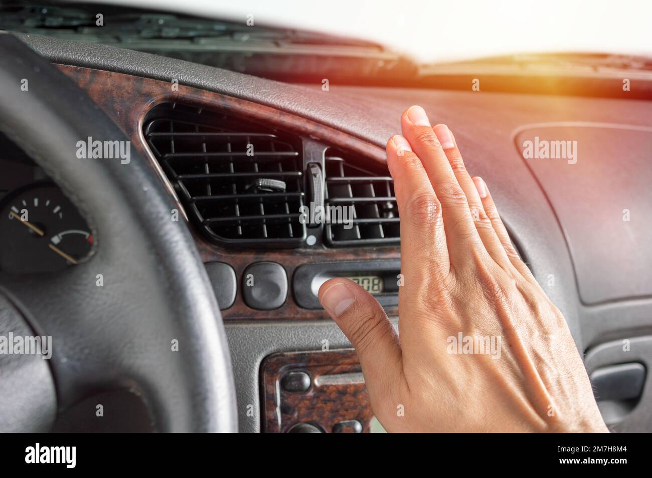 Closeup of hand driver man checking adjusting air from conditioning the cooling system with flow of cold air in car. Stock Photo
