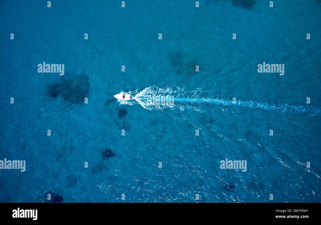 An aerial view of a motorboat in the clear blue water of the ocean ...