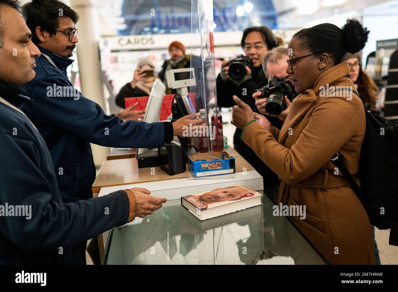 Sarah Nakana, 46, buys the newly released autobiography from the Duke of Sussex at WHSmith's in Victoria Station, London, as the book became available to purchase at midnight. Picture date: Tuesday January 10, 2023. Stock Photo