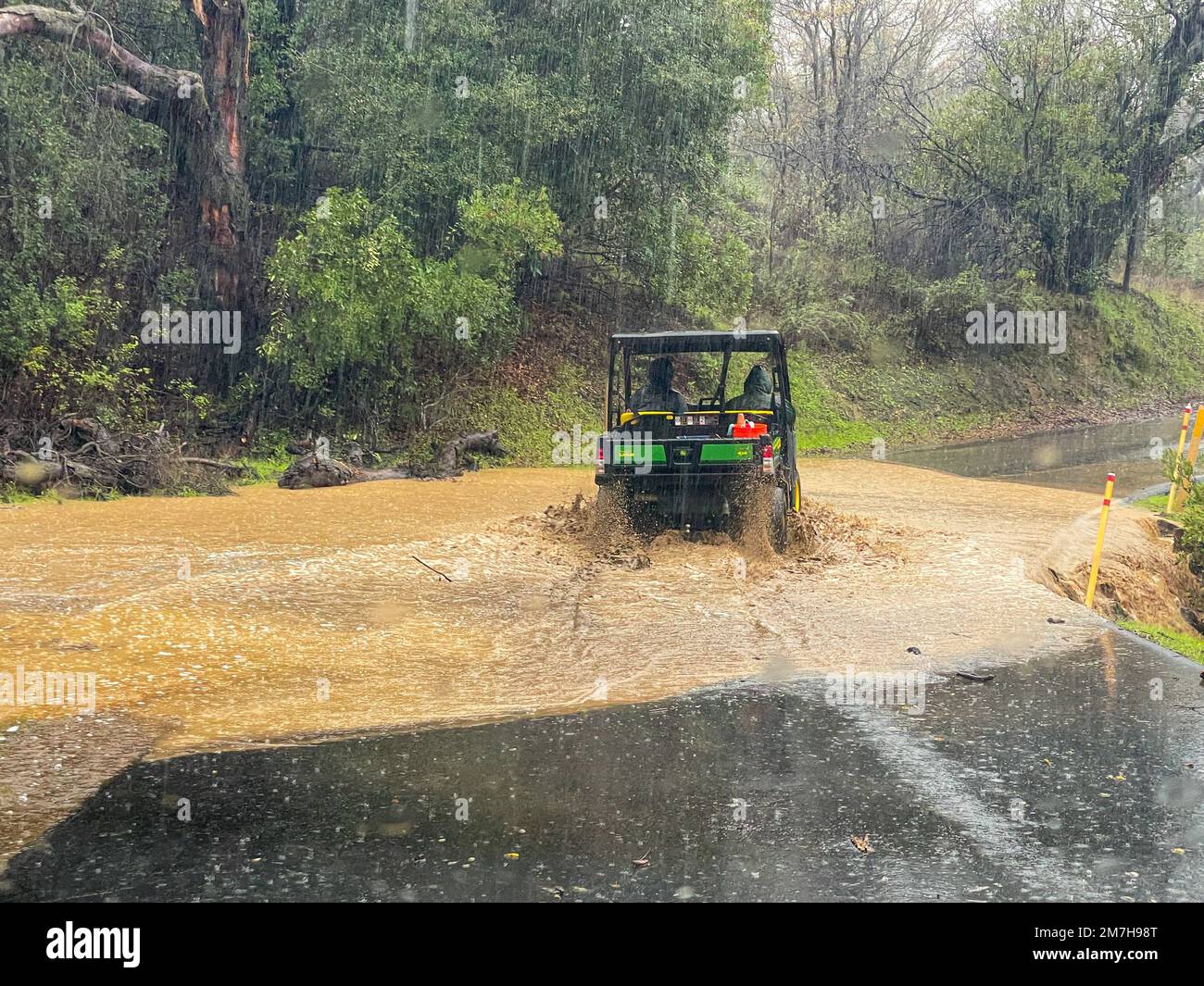 Santa Barbara, California, U.S.A. 9th Jan, 2023. A Rancho Oso Park Ranger attempts to cross a flooded and muddy driveway, on the way to clear a boulder from the road. Flash Flooding in Santa Barbara's Los Padres National Forest has caused residents and vacationers at Rancho Oso Horse Ranch and Campground on Paradise Road to be trapped until rains cease and roads can be cleared.Today marks the exactly the fifth anniversary of the nearby Montecito Mudslides, which killed 23 people, leaving Santa Barbara County on edge. Currently much of the county is under evacuation or stay-at-home orde Stock Photo