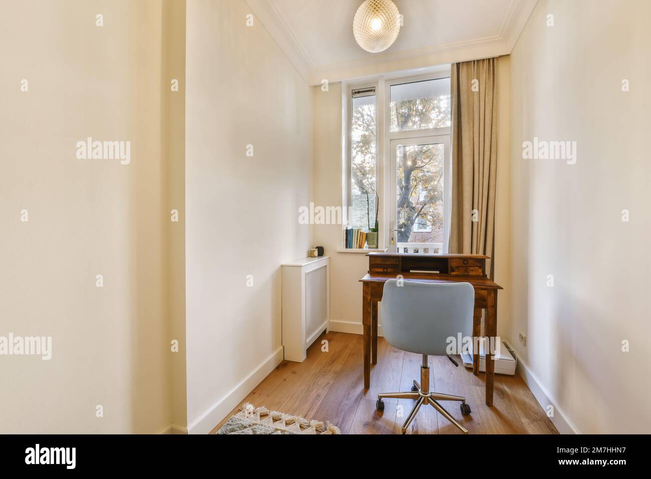 a small room with a desk and chair in front of the window that looks ...