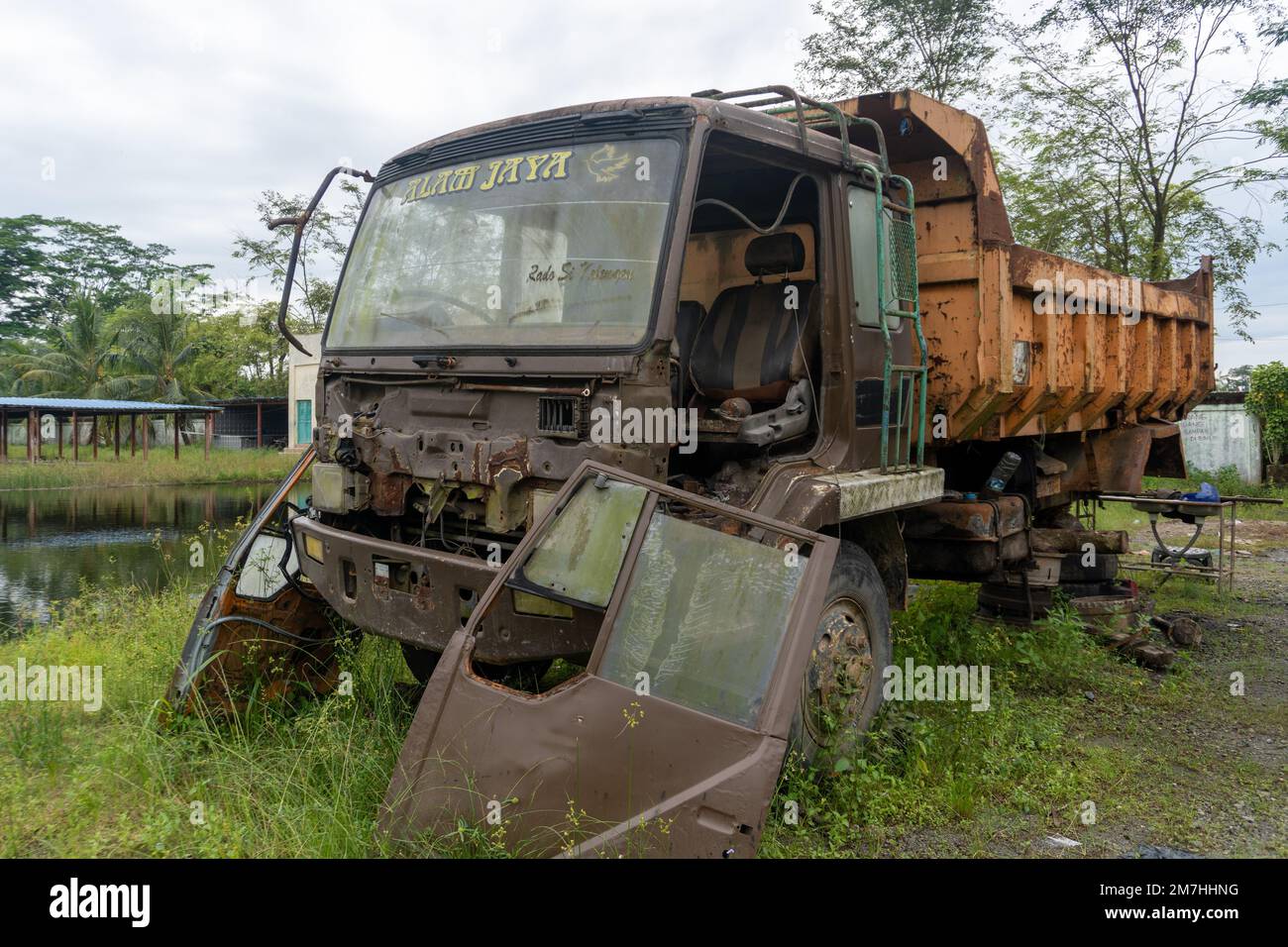 Abandoned broken trucks in the middle of nature covered in wild bushes close up Stock Photo