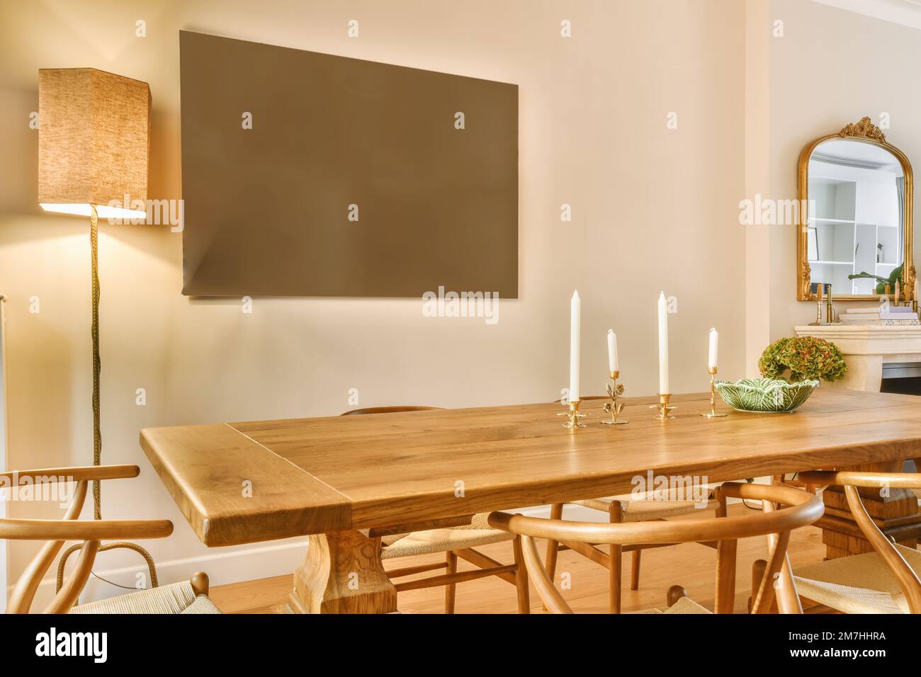 a dining table and chairs in a room with a large screen on the wall ...