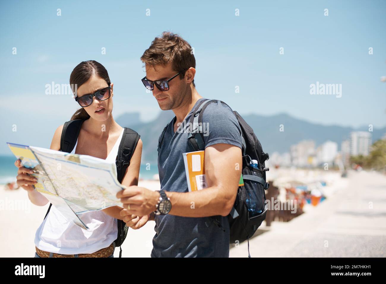 Better get learning the local language. a young couple looking at a map ...