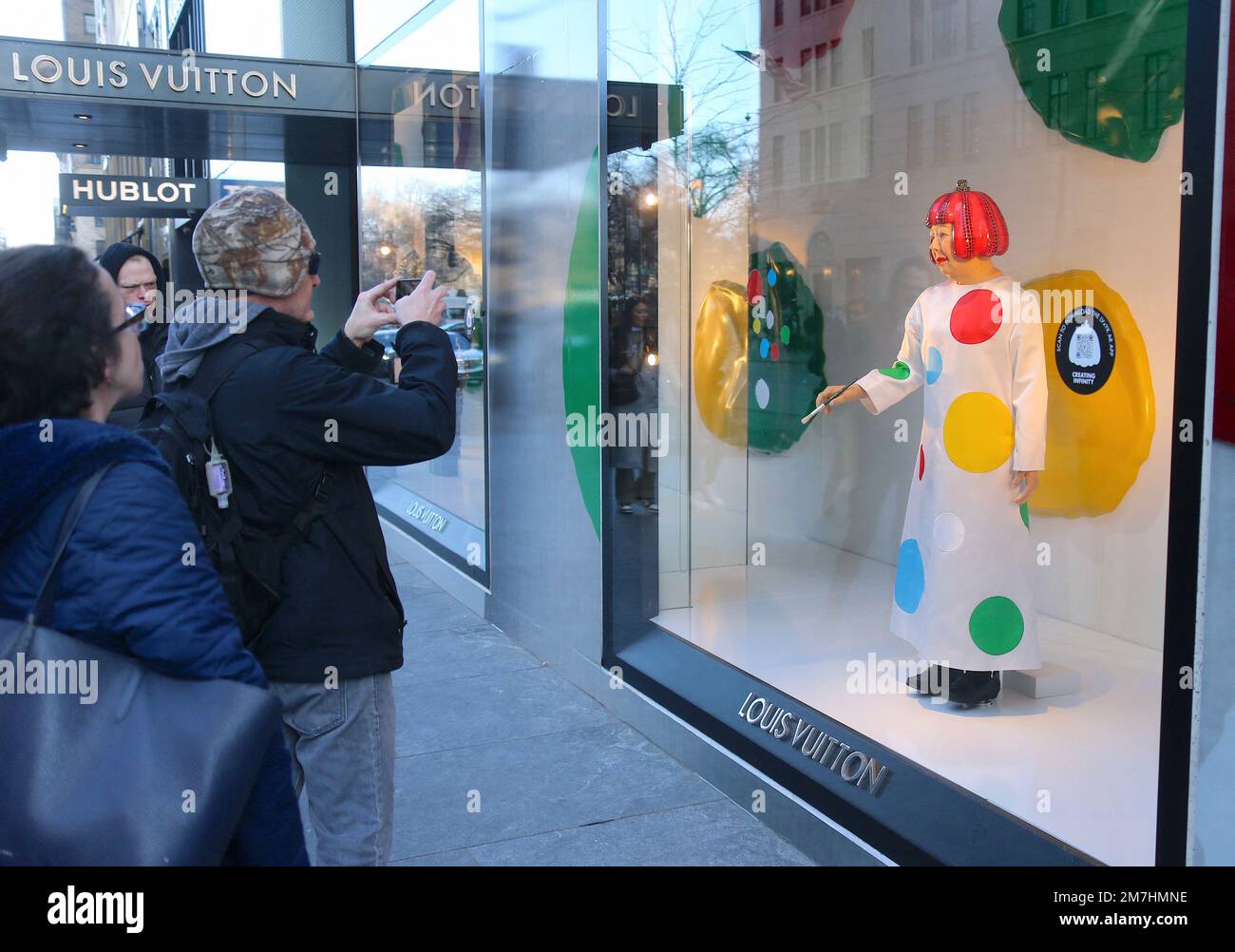 New York, USA. 09th Jan, 2023. Japanese artist Yayoi Kusama robot painting  her famous spots in the window at the Louis Vuitton Fifth Avenue store in  New York City, NY, USA on