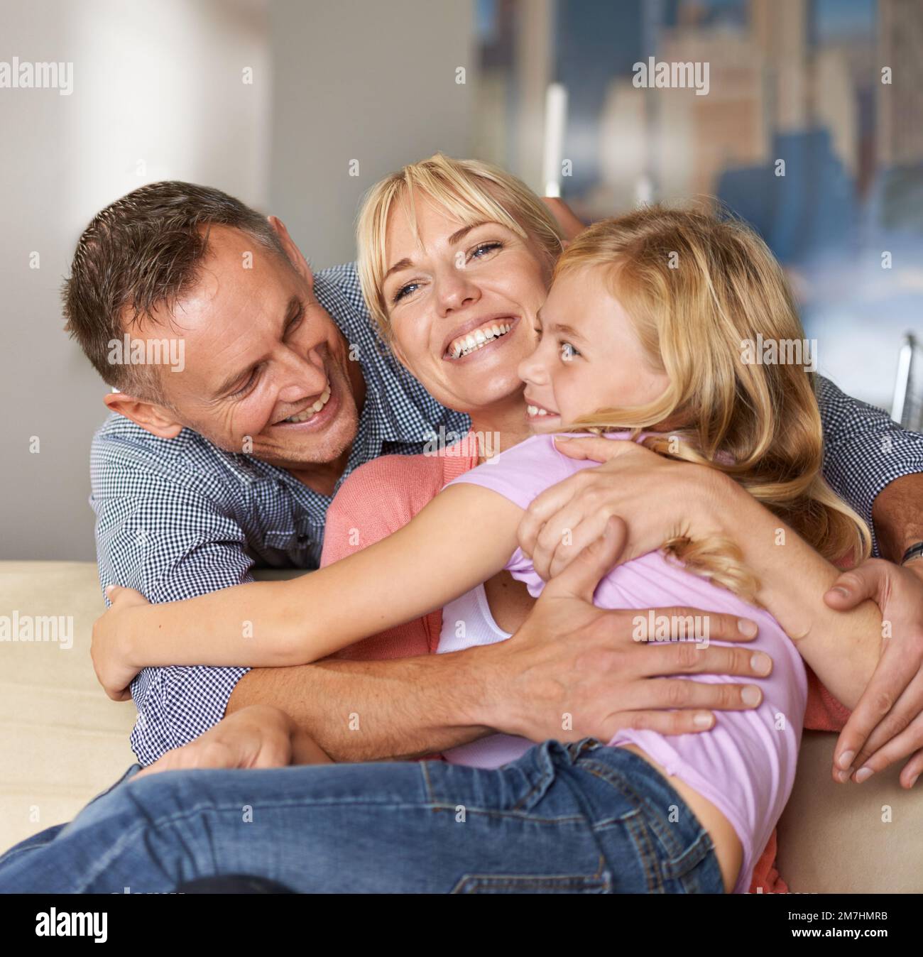 Home is definitely where the heart is. a loving family embracing each other on the sofa. Stock Photo