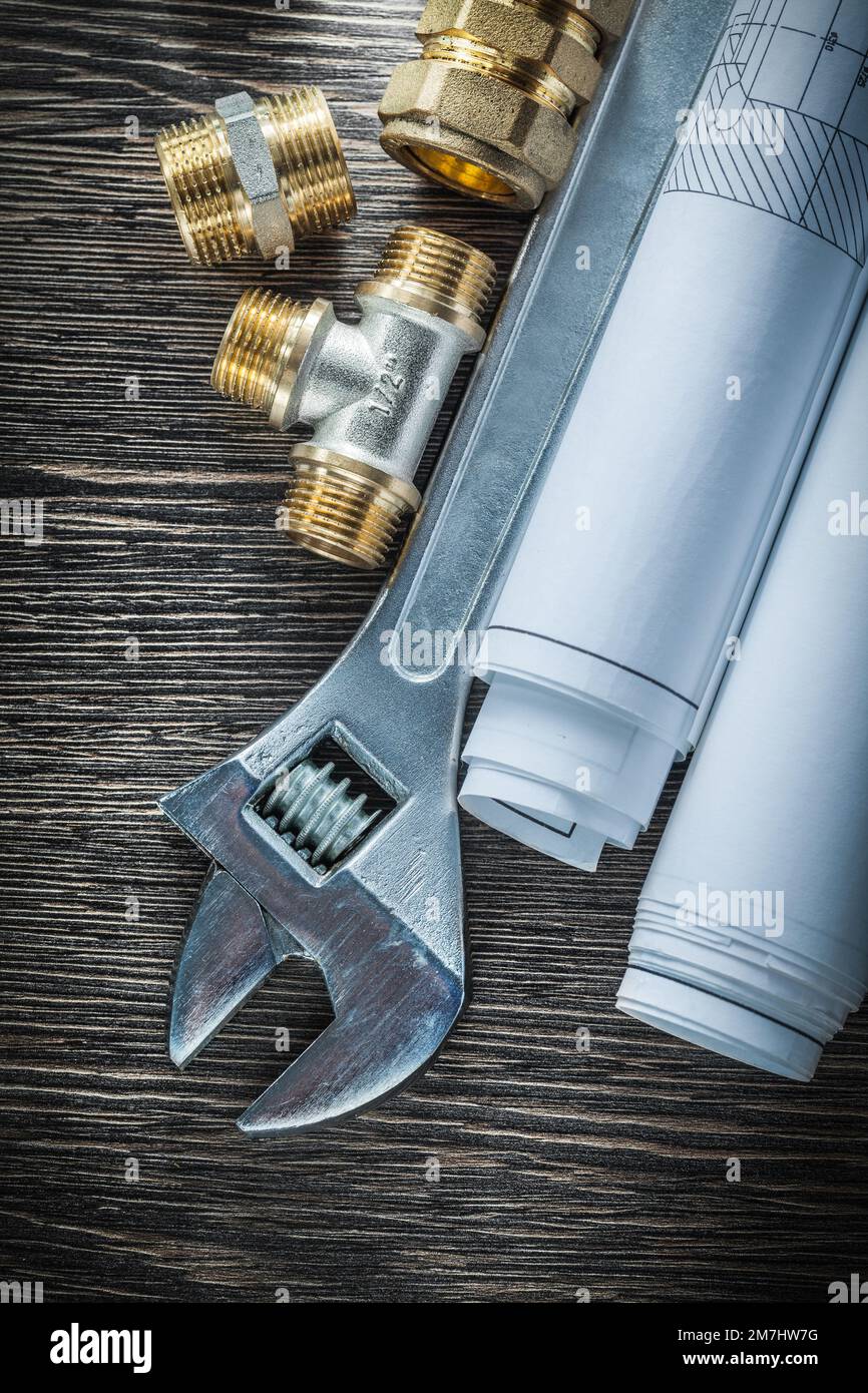 Adjustable wrench plumbing pipe fittings rolled blueprints Stock Photo