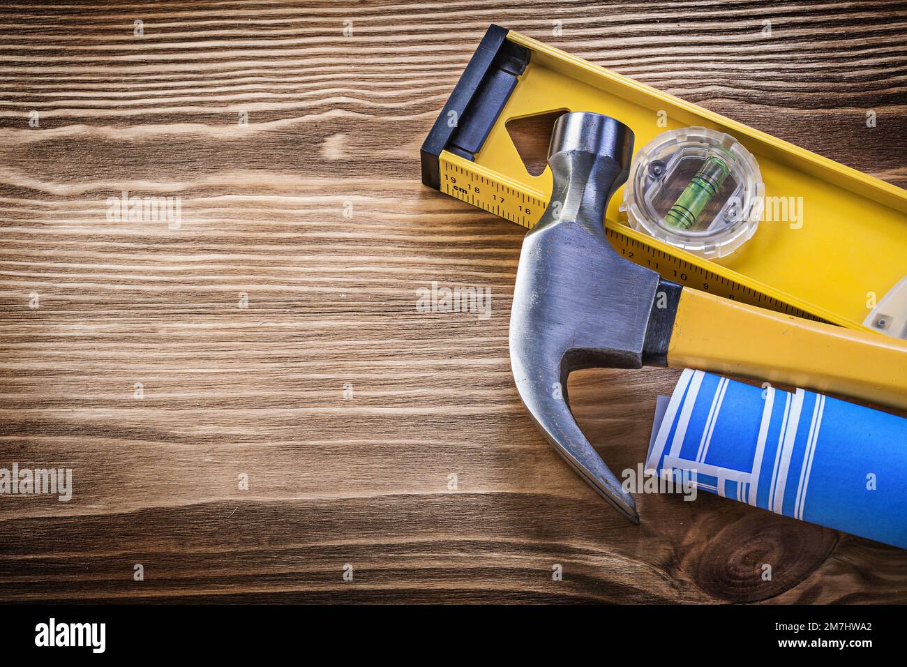 Blue blueprint claw hammer construction level on vintage wooden board