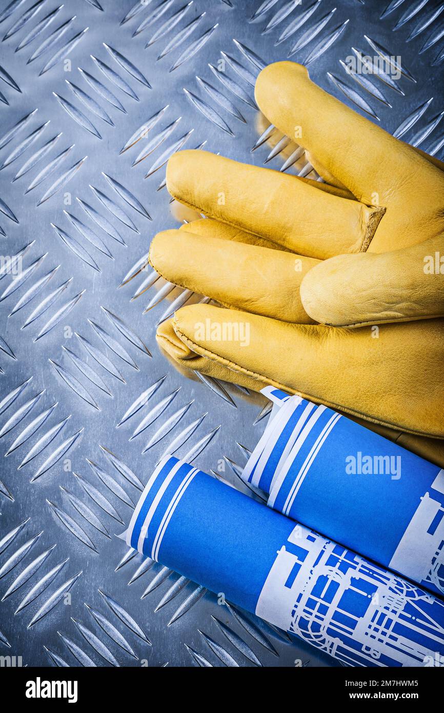 Blue engineering drawings leather safety gloves on corrugated metal ...