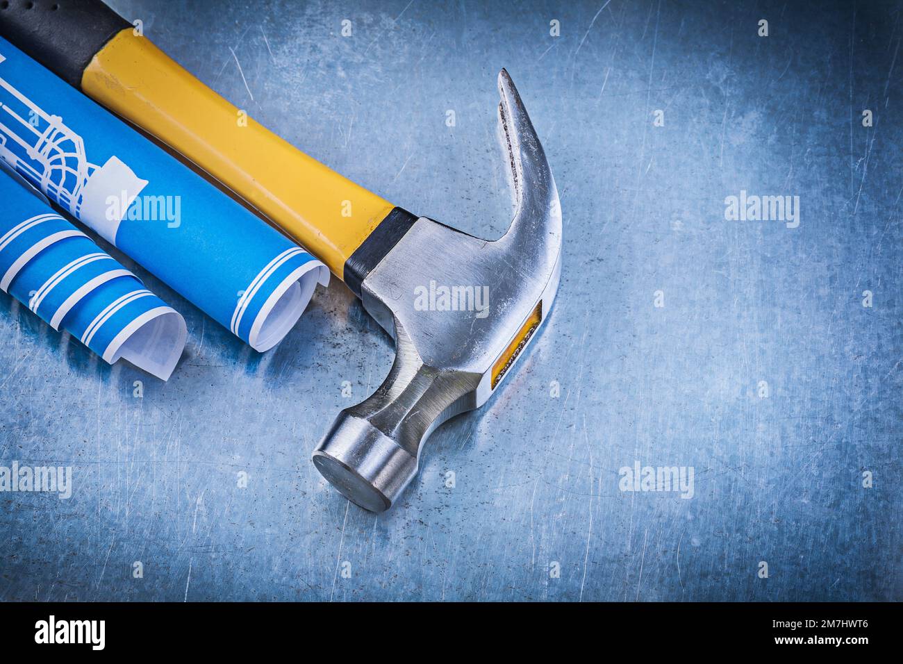 Blue rolled engineering drawings claw hammer on metallic background ...