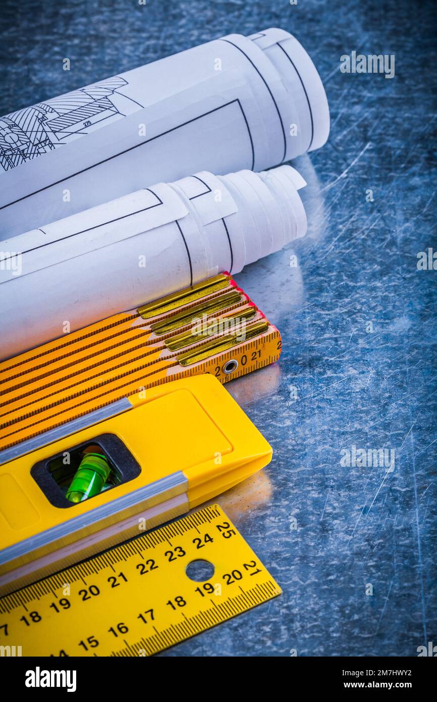 Blueprint rolls yellow ruler construction level and wooden meter on ...