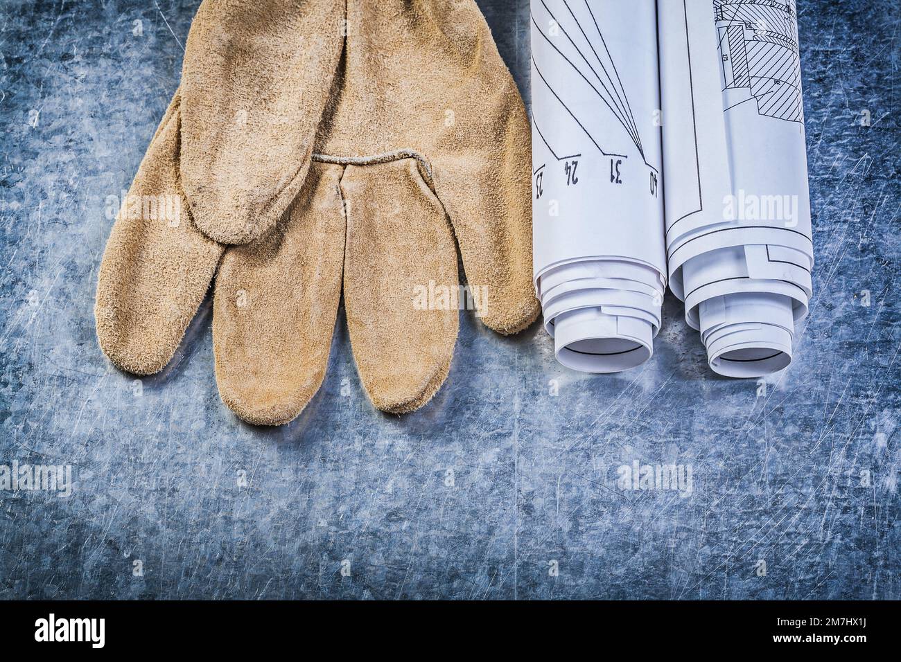 Blueprints safety gloves on metallic background construction concept. Stock Photo