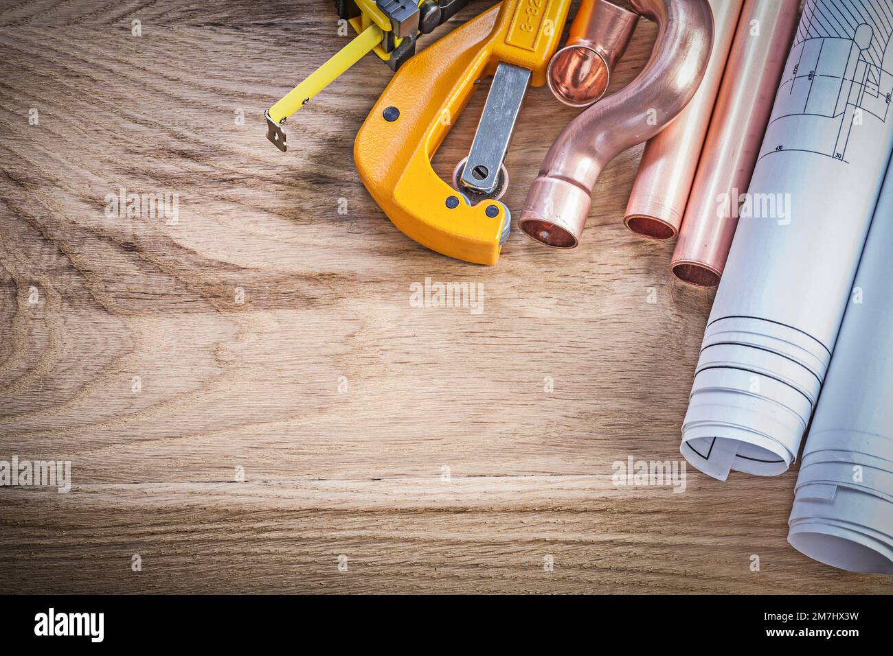 Blueprints tape measure water pipe cutter fittings on wooden board plumbing concept Stock Photo