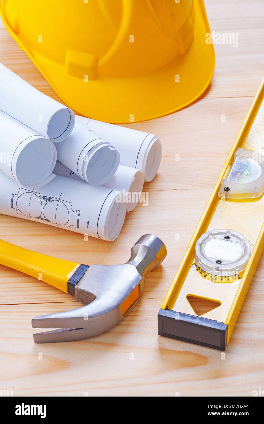 claw hammer rolled blueprints construction level hardhat on wooden ...