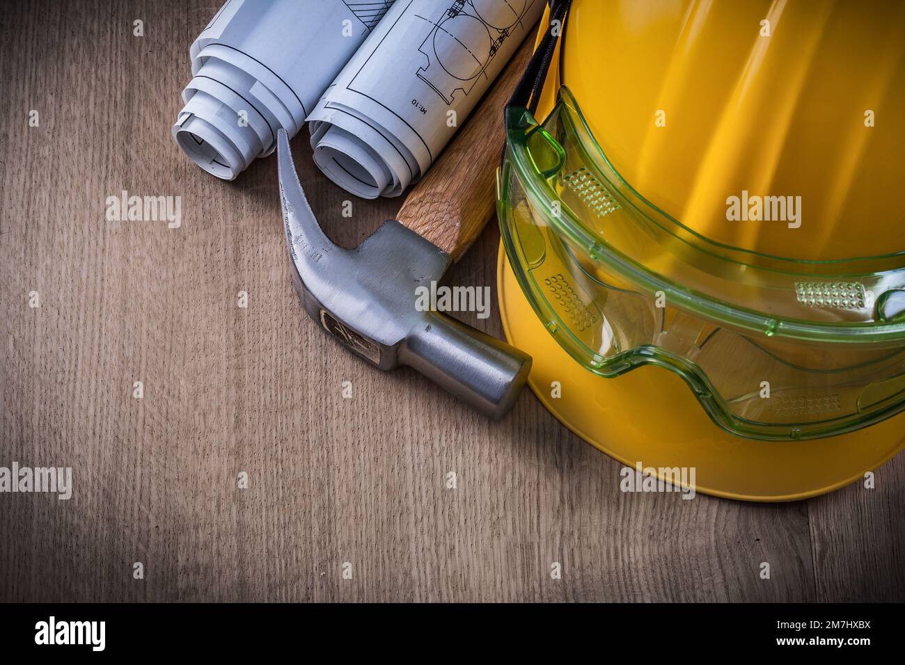 Claw hammer safety goggles construction drawings and hard hat. Stock Photo