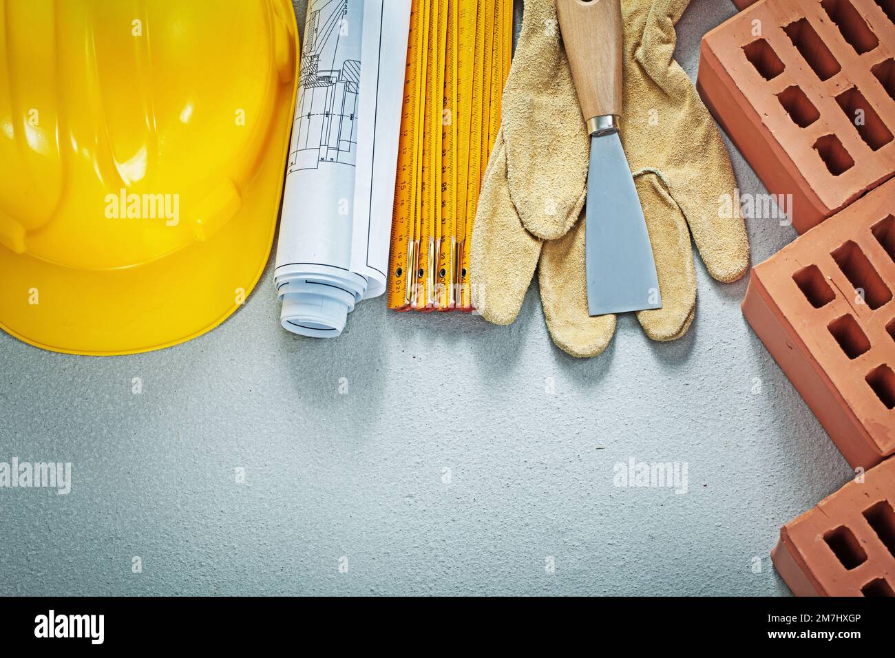 Collection of bricklaying tools on concrete surface top view