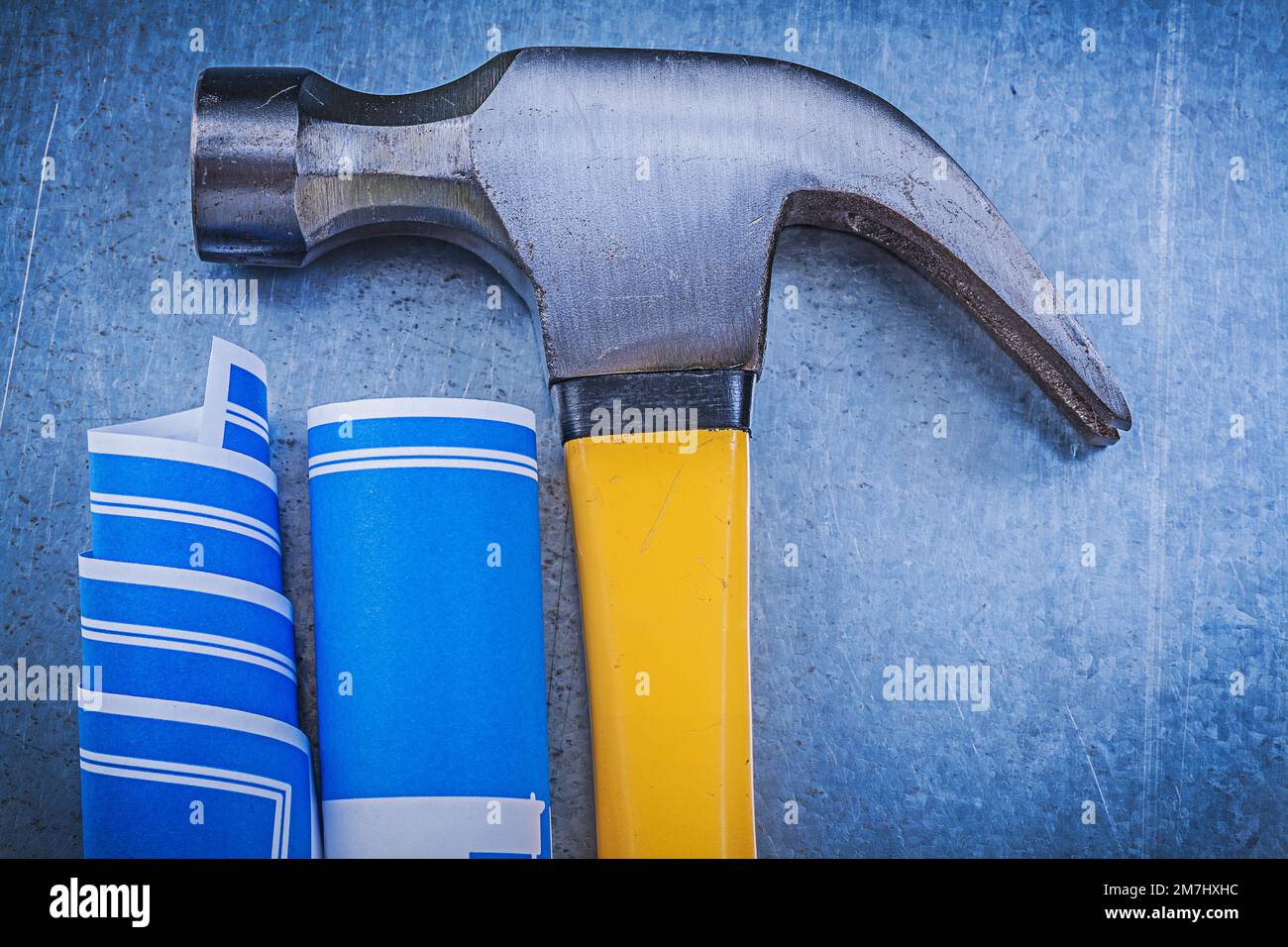 Composition of blue construction plans claw hammer on metallic ...