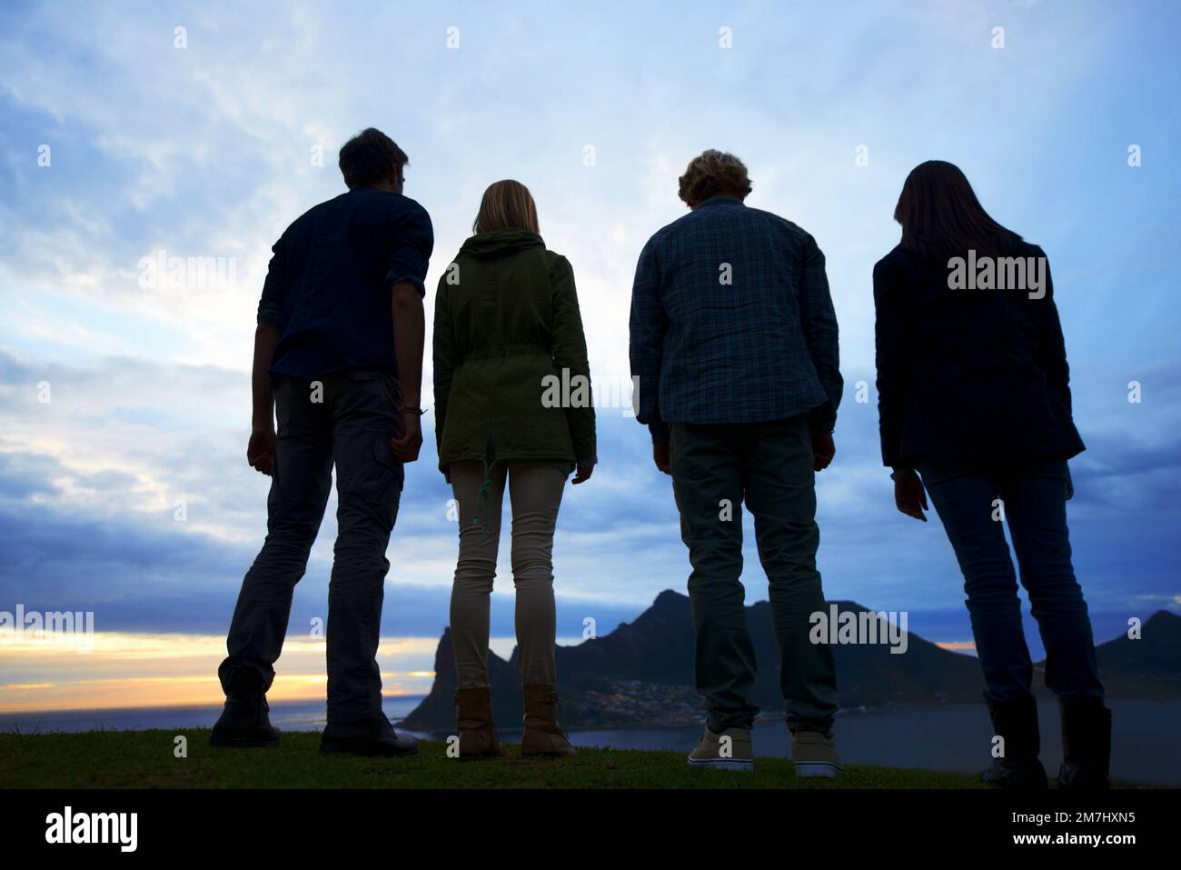 Majestic views...A group of young adults watching the sunset from a high viewpoint. Stock Photo